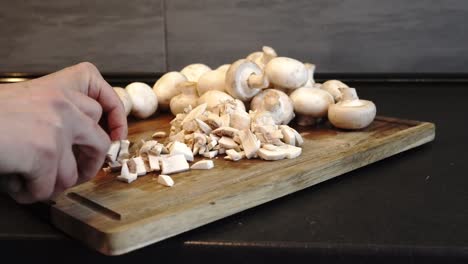 Slicing-mushrooms-in-the-kitchen-as-a-woman-skillfully-cuts-white-mushrooms-into-pieces-on-a-wooden-board