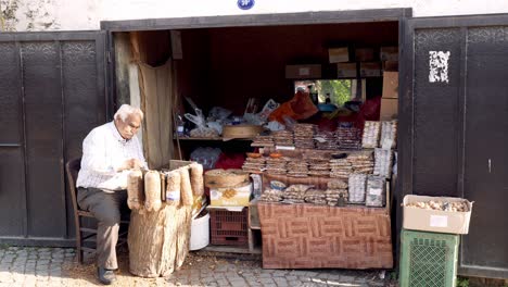 Street-vendor-breaking-and-shelling-nuts-with-hammer-to-sell-from-his-stall