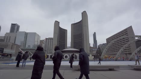 Gente-Patinando-Sobre-Hielo-Y-Visitando-El-Ayuntamiento-De-Toronto,-La-Plaza-Nathan-Phillips
