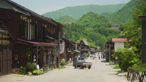 Vista-Idílica-De-La-Calle-En-Shirakawago-Con-Un-Paisaje-De-Ladera-Forestal-En-El-Fondo