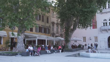 Life-at-its-best,-catching-a-bit-of-the-traditional-way-in-Dalmatian-town-of-Zadar,-Croatia-with-people-sitting-in-the-shade-of-trees-and-talking,-Five-Wells-square-Croatia