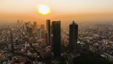 Aerial-view-descending-in-front-of-the-Reforma-avenue-skyscrapers,-sunset-in-Mexico-city