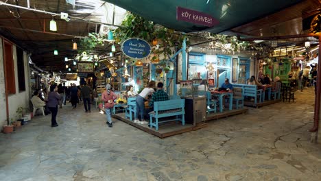 La-Gente-En-El-Mercado-Cubierto-De-La-Aldea-Turca-Con-Cafés-Y-Puestos-De-Souvenirs.