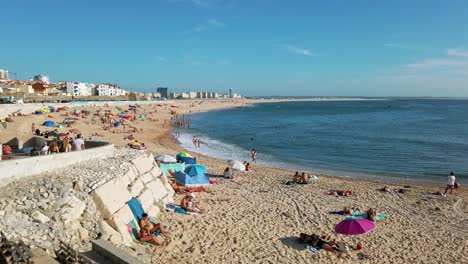 Gente-Tomando-El-Sol-Y-Relajándose-En-La-Playa-De-Arena-De-Figueira-Da-Foz-En-Otoño,-Portugal