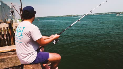 Joven-Pescando-Lubina-Rayada-En-El-Muelle-Del-Estado-De-Maine