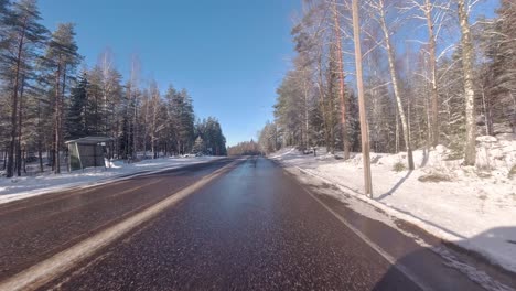 Amidst-the-snow-covered-pines,-the-car-glides-along-the-road,-creating-a-picturesque-scene-of-winter-wonder