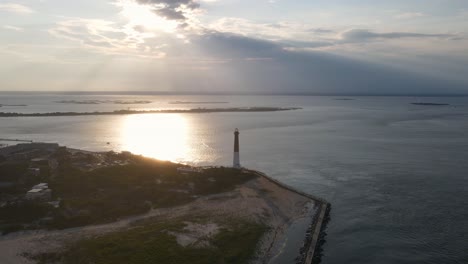 A-high-flying,-4K-drone-shot-of-the-Barnegat-Lighthouse,-located-on-the-northern-tip-of-Long-Beach-Island-in-Ocean-County,-New-Jersey,-U