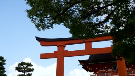 Giant-Red-Torii-Gate-With-Tree-Branch-In-View-Against-Blue-Sky