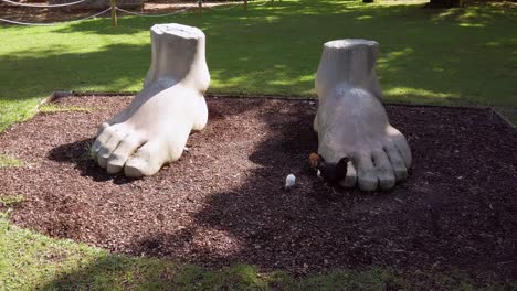 Fußförmige-Skulptur-Mit-Herumlaufendem-Huhn-Im-Marechal-Carmona-Park,-Cascais,-Portugal