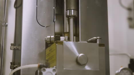 Close-up-of-an-automatic-corking-device-in-wine-bottling-machinery