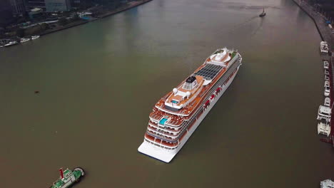Top-Down-Aerial-Shot-of-Viking-Sun-Cruise-Ship-Arriving-on-Huangpu-River-in-Shanghai,-China