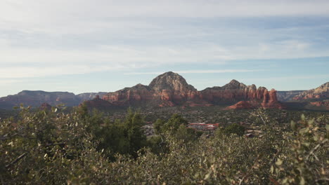 View-of-Sedona-Arizona-beautiful-rock-formations,-city,-and-mountains-on-an-overcast-day---push-in-shot-of-horizon