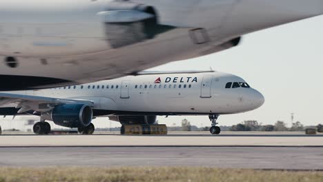 Mittlere-Aufnahme-Mehrerer-Delta-Verkehrsflugzeuge,-Die-Eine-Landebahn-Am-Flughafen-Atlanta-In-Atlanta,-Georgia,-Hinunterrollen