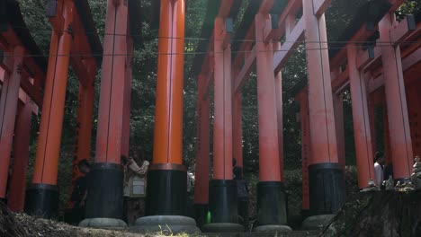 Seitenansicht-Der-Roten-Torii-Tore-Bei-Fushimi-Inari-Taisha-Mit-Touristen,-Die-Hindurchgehen