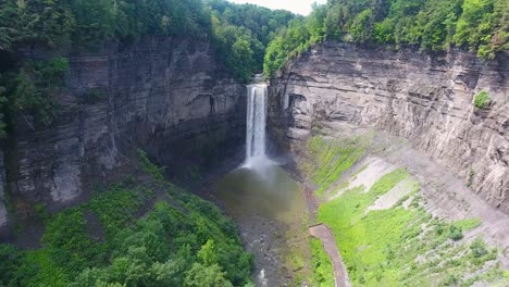 A-4K-drone-shot-of-Taughannock-Falls,-the-tallest-single-drop-waterfall-east-of-the-Rocky-Mountains,-which-leads-into-Cayuga-Lake,-located-in-the-town-of-Ulysses,-New-York