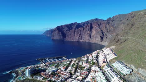 Los-Gigantes-aerial-of-port,-resort-town-with-hotel-in-Tenerife,-Canary-Island-Spain
