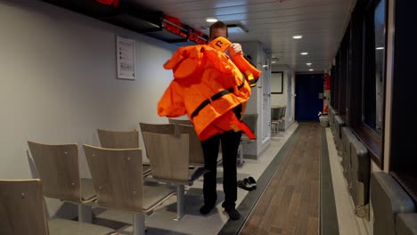 Captain-explain-and-demonstrate-how-to-put-on-lifejacket-onboard-ship