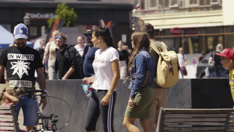 Slow-motion-shot-of-people-walking-and-enjoying-themselves-in-the-town-square-on-a-sunny-day