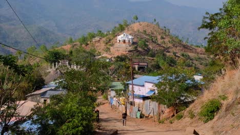 Small-white-chapel-and-local-community-houses-in-rural-countryside-hilly-landscape-of-Timor-Leste,-Southeast-Asia