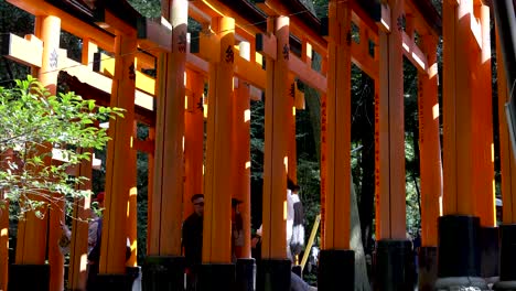Außenansicht-Der-Reihe-Roter-Torii-Tore-Bei-Fushimi-Inari-Taisha,-Durch-Die-Touristen-Laufen