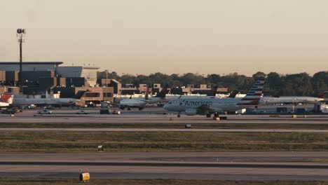 Wide-Pan-shot-of-ATL-airport-in-Atlanta,-Georgia-as-an-American-Airlines-airplane-taxis-down-the-runway