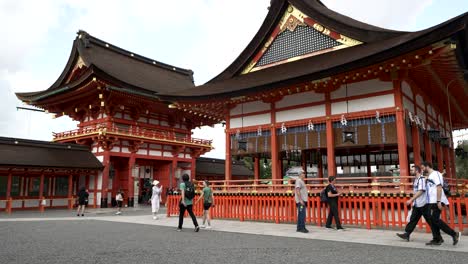 Touristen,-Die-Um-Fukakusa-Yabunouchicho-Herumlaufen,-Mit-Turmtor-Im-Hintergrund-Am-Fushimi-Inari-Schrein