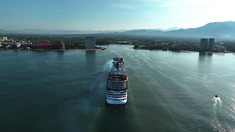 Aerial-ascending-shot-of-a-large-cruiseliner-arriving-in-Puerto-Vallarta,-Mexico
