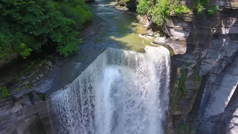A-4K-drone-shot-of-Taughannock-Falls,-the-tallest-single-drop-waterfall-east-of-the-Rocky-Mountains,-which-leads-into-Cayuga-Lake,-located-in-the-town-of-Ulysses,-New-York