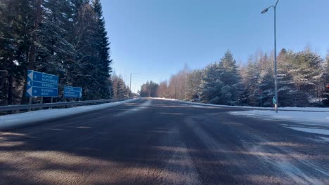 Ein-Auto-Fährt-Die-Straße-Entlang,-Flankiert-Von-Schneebedeckten-Bäumen,-Die-Eine-Malerische-Winterszene-Schaffen