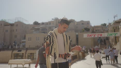 Joven-Leyendo-La-Torá-Y-Orando-Cerca-Del-Muro-De-Las-Lamentaciones,-Jerusalén,-Israel