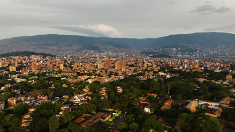 Aerial-rising-shot-over-the-cityscape-of-Medellin,-sunny-evening-in-Colombia