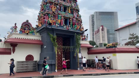 Frontal-view-of-tourists-at-the-main-entrance-of-Sri-Mariamman-Temple-in-the-heart-of-Chinatown,-Singapore