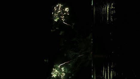Aufnahme-Eines-Großen-Feuerwerksfestivals-In-Der-Nähe-Der-Küste-Mit-Einer-Spiegelung-Auf-Dem-Meer-–-Vertikale-Aufnahme