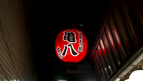 Single-Round-Illuminated-Hanging-Red-Lantern-Outside-Business-Establishment-In-Side-Street-In-Kyoto