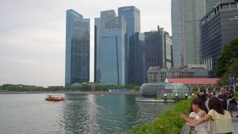 Touristenboote-Fahren-Entlang-Des-Singapur-Flusses-Vor-Der-Skyline-Des-Zentralen-Geschäftsviertels-Marina-Bay