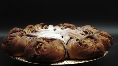 Präsentiert-Festlichen-Sternförmigen-Kuchen:-Traditionelles-Polnisches-Mohnbrötchen,-Makowiec-Auf-Schwarzem-Hintergrund
