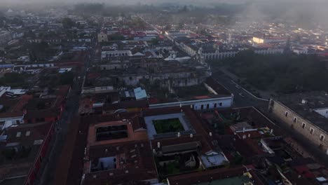 Historische-Stadt-Antigua-Mit-Agua-Vulkan-Hintergrund-Während-Eines-Nebligen-Morgens,-Luftaufnahme