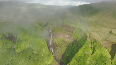 Soaring-through-clouds-to-reveal-Cascata-da-Ribeira-Grande-in-Flores-Azores---Drone-shot