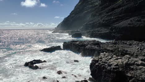 Hawaii's-coast-captivates-with-its-perilous-beauty,-featuring-towering-white-waves-and-volcanic-rock