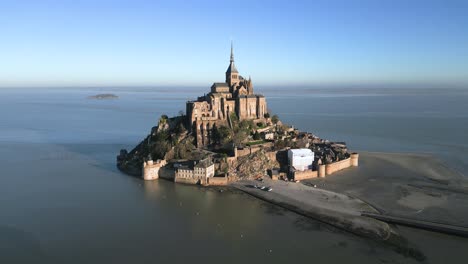 French-Mont-Saint-Michel-Castle-in-Normandy-France,-Aerial-Drone-Flying-Around-in-Broad-Daylight-at-High-Tide
