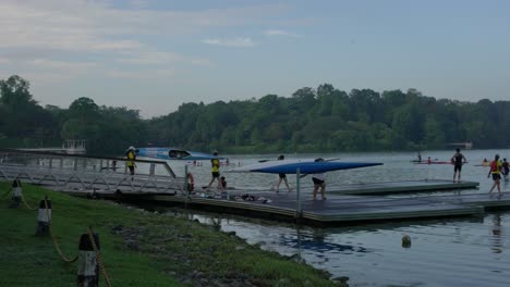 Panning-view-of-students-carrying-kayak-boats-to-the-paddle-lodge-and-canoe-in-Macritchie-Reservoir-in-Singapore