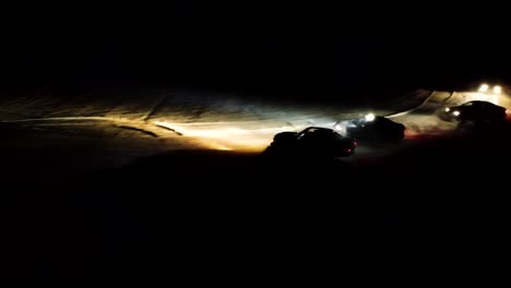 Winter-drift-competition-on-snowy-racetrack-during-night,-led-light-illuminate