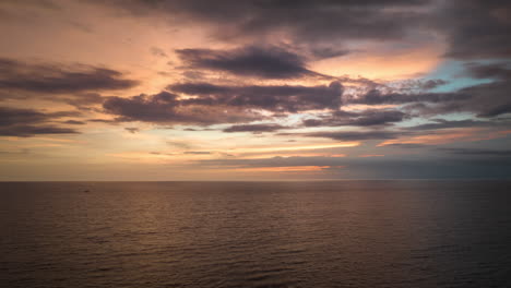 Sunsets-over-Flores-Sea,-horizon-transforms-into-moody-display-of-color