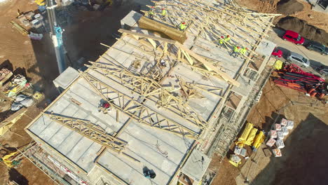 Aerial-view-tilting-away-workers-at-an-sunny-apartment-building-construction-site