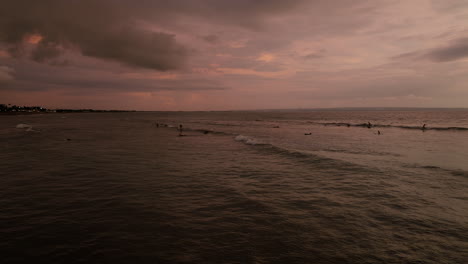 Sunset-Over-Tropical-Sea-With-Surfers-On-Canggu-Beach-In-Dalung,-Kuta-Utara,-Bali-Indonesia