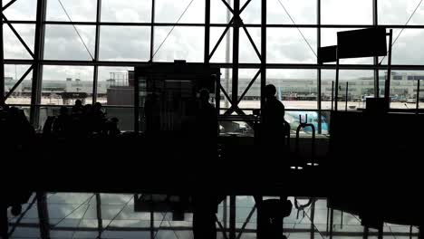 Passengers-silhouette-walking-to-the-departure-gate-at-Brussels-Airport-in-Zaventem,-Belgium---Cinematic-travel-shot