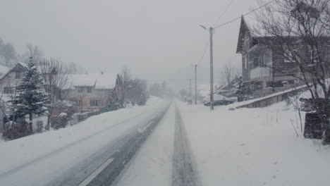 Fahren-Auf-Einer-Schneebedeckten-Straße-Durch-Eine-Kleine-Stadt