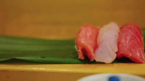 Nigiri-Sushi-on-Banana-Leaf,-Close-Pan-of-Gourmet-Fish-Market-Restaurant