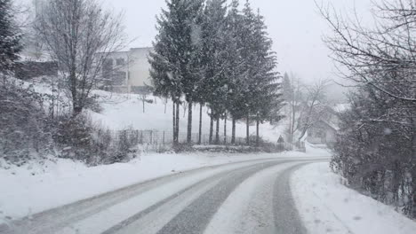 Fahren-Im-Wald-Auf-Kurviger-Straße-Mit-Starkem-Schneefall