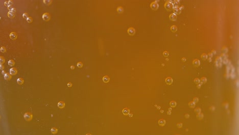 Blasen,-Die-Von-Einer-Glatten-Oberfläche-In-Einem-Bernsteinfarbenen-Bier-Ausgehen